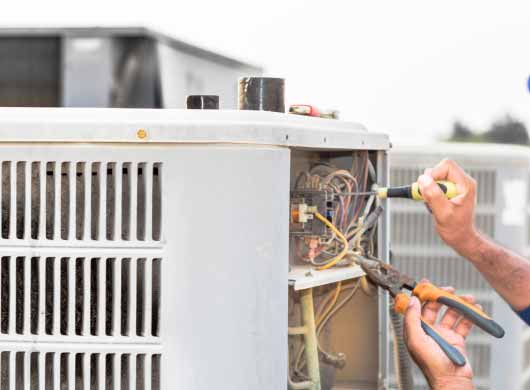 Hands repairing an AC Unit